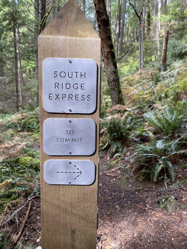 hiking mount gardner from the Laura road entrance this sign post shows the south ridge express and to summit with an arrow pointing right.