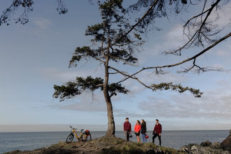 Cape Roger Curtis Lighthouse - Whale Trail Hike - Bowen Island BC Canada - hikers under arbutus tree ebiking