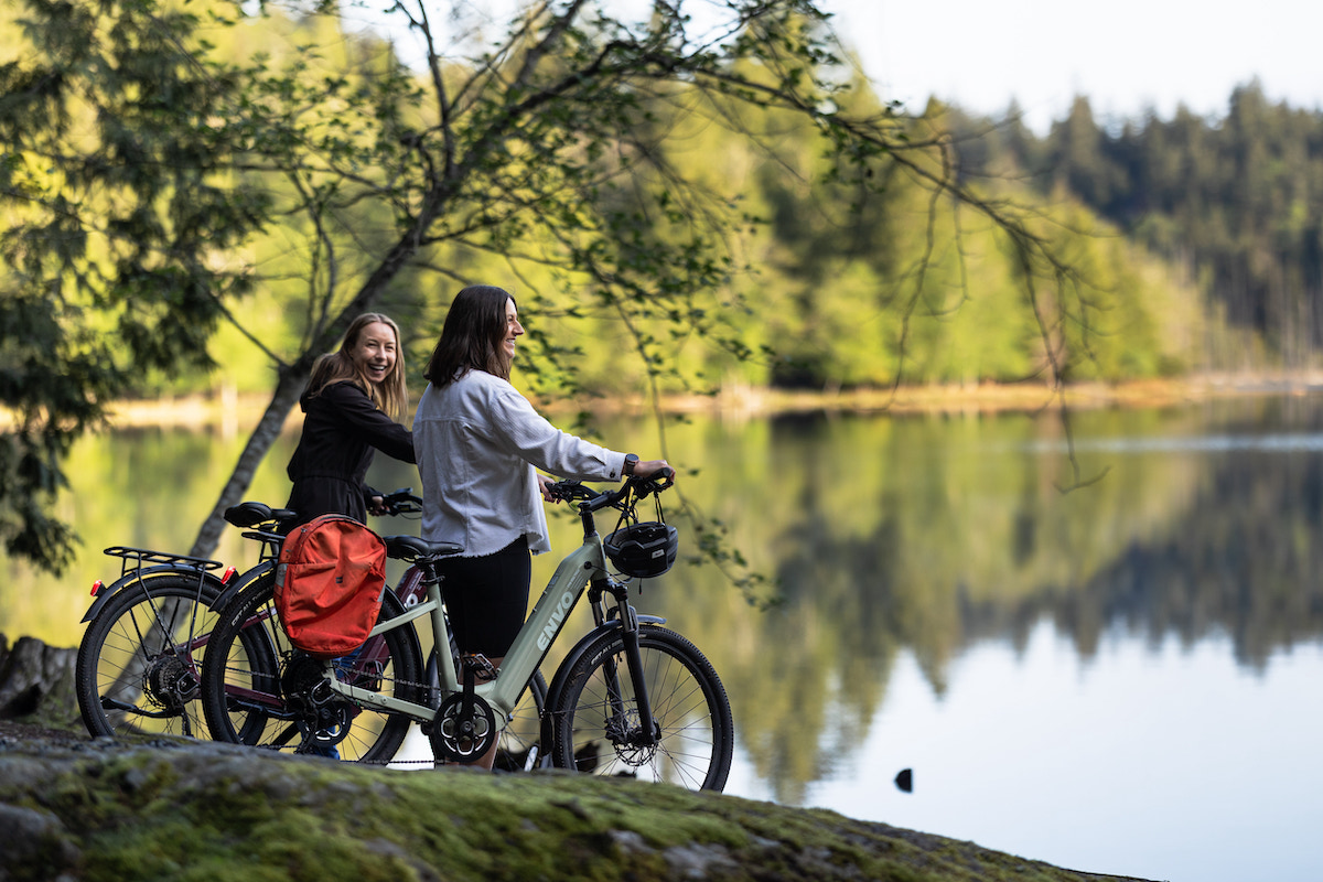8am at Killarney lake, eBike rental riders look out at Killarney Lake, surrounded by old growth trees, forest, nature, hiking trails, beavers, deer, birds and other wildlife. They forgot what Vancouver was like.